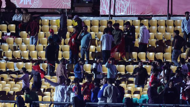 Spectators leave the stands after authorities evacuated the stadium during the match between the Punjab Kings and Delhi Capitals. (Photo by Pankaj Nangia/Getty Images)