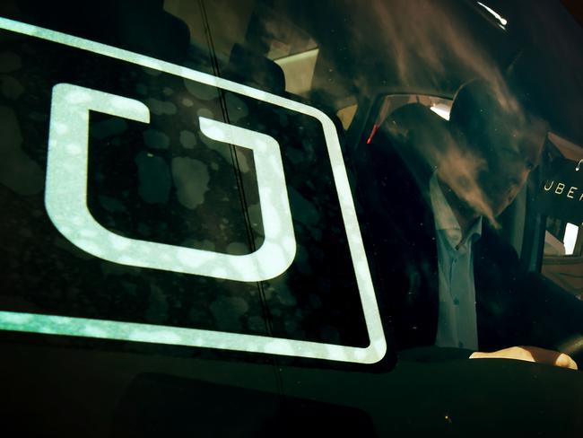 A man checks a vehicle at the first of Uber's 'Work On Demand' recruitment events where they hope to sign 12,000 new driver-partners, in South Los Angeles on March 10, 2016. / AFP PHOTO / Mark Ralston