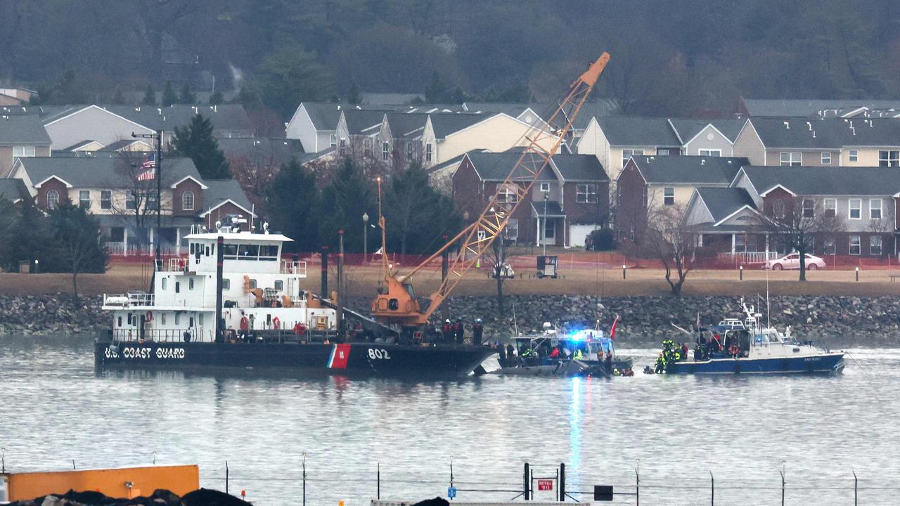 A Coast Guard crane arrives to remove the wreckage of a military Black Hawk helicopter after the crash of an American Airlines plane on the Potomac River.