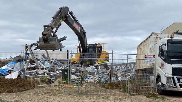 A bulldozer demolishes the home at 9 Gold Coast Drive.