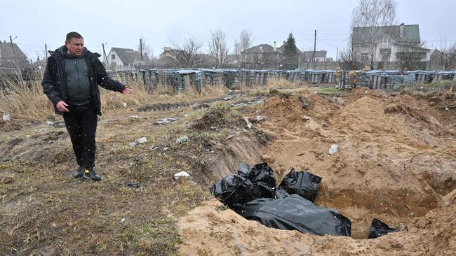 A Bucha resident beside a mass grave in the town of Bucha. Picture; AFP.