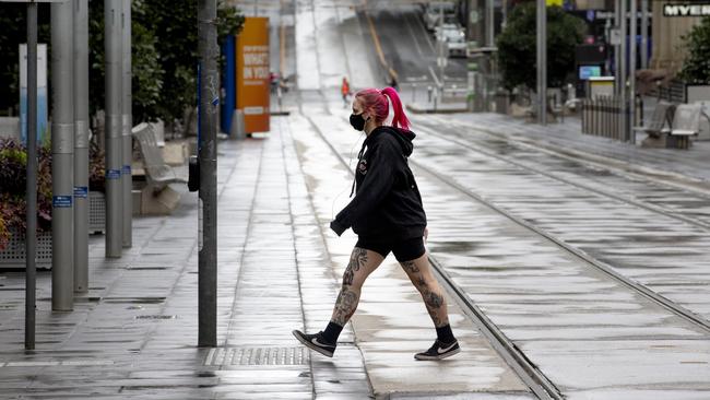 A Melburnian crosses a deserted Bourke St in the CBD on Tuesday morning during stage 4 restrictions in Melbourne. Picture: NCA NewsWire / David Geraghty