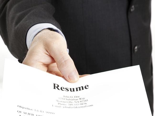 Closeup of a businessman's hand holding out a resume.  Focus on the hand and the word Resume. Picture: iStock