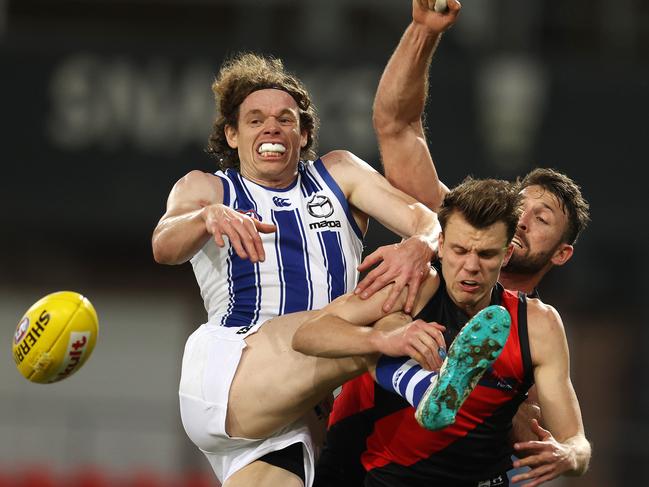 AFL Round 6. Essendon vs North Melbourne at Metricon Stadium, Gold Coast. 11/07/2020.   Ben Brown of the Kangaroos is doubled teamed in the marking contest by Jordan Ridley and Cale Hooker of the Bombers   . Pic: Michael Klein