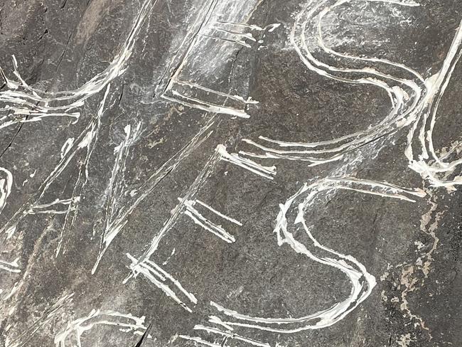 Vandals have carved "Jesus Saves" into a rock with significance to the indigenous people of Mt Beerwah. Picture: DFES