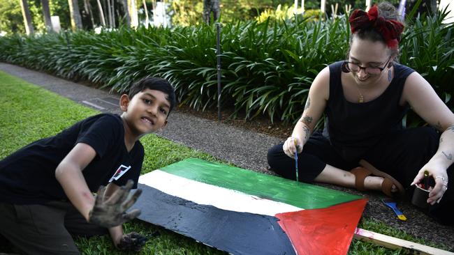 Young Territorian Abdul Qawi painting a sign at a pro-Palestine protest outside of the NT Parliament house on Friday October 27 calling for a ceasefire 20-days into the Gaza conflict.