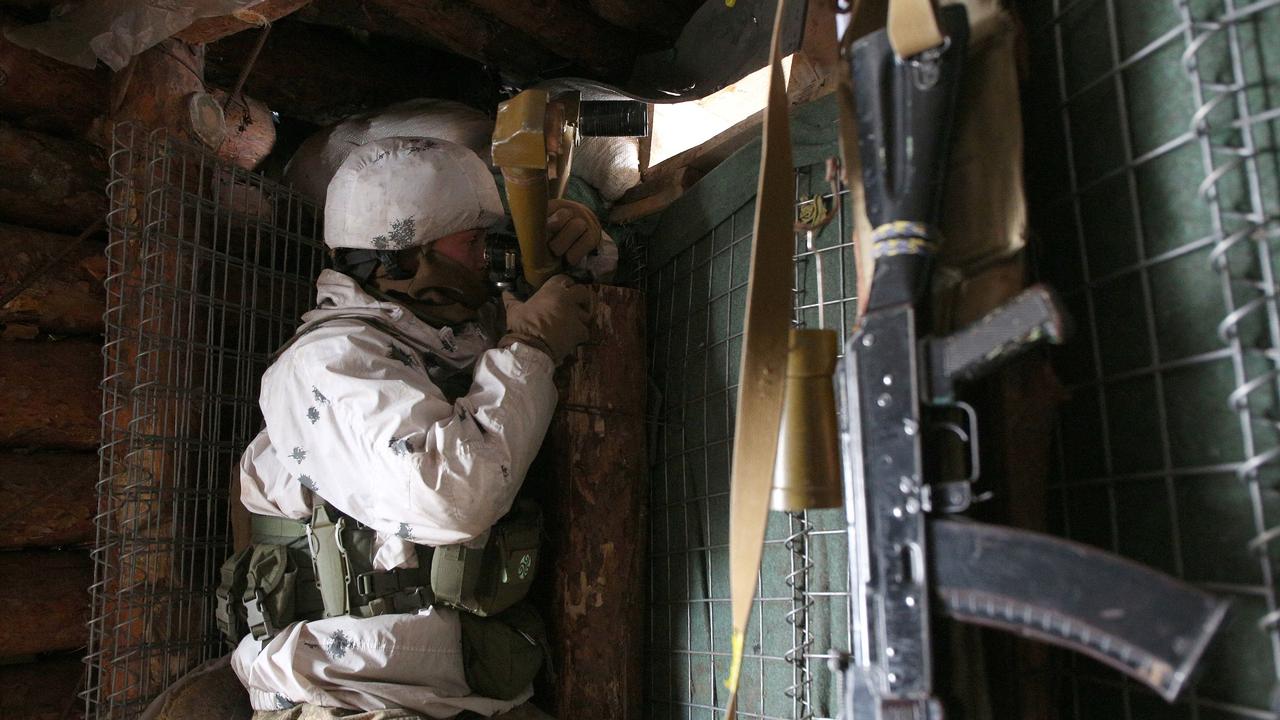 An Ukrainian Military Forces serviceman watches through spyglass in a dugout on the frontline with Russia-backed separatists near Gorlivka, Donetsk region. Picture: Anatolii STEPANOV / AFP