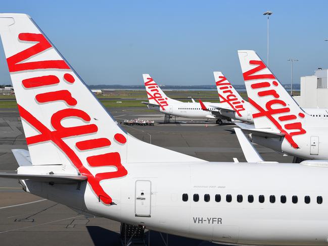 A general view of Virgin Australia aircraft parked at Sydney Domestic Airport, in Sydney, Tuesday, April 21, 2020. Virgin confirmed it had gone into administration on Tuesday, threatening up to 10,000 airline jobs after a board meeting of its international shareholders voted on Monday against providing additional financial support. (AAP Image/Dan Himbrechts) NO ARCHIVING