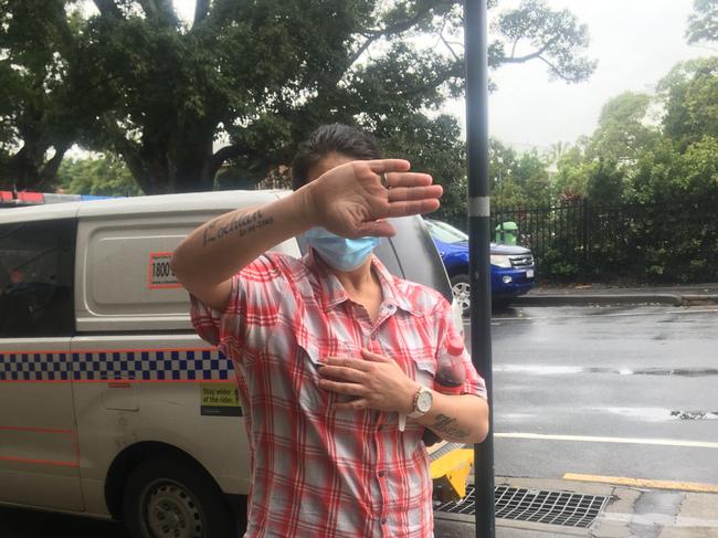 Renee Sheree Brackin hides her face outside court after pleading guilty to 23 offences including stealing, fraud, and receiving tainted property.