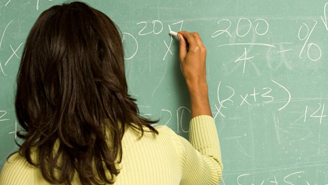 Female student writing on blackboard