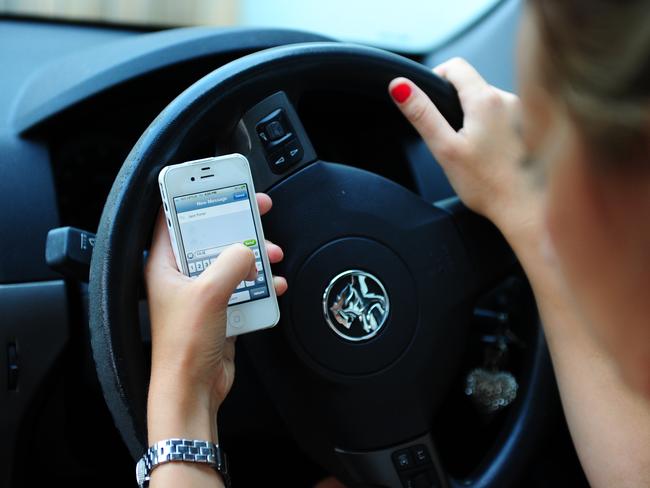 Having a mobile phone in hand while driving could cost you $330 and 3 demerit points. Photo Tom Huntley / The Observer