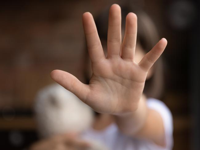 Crop close up of little girl child stretch hand show no gesture protest against domestic violence. Small teen child stand against discrimination or school abuse. Childhood problem, voice concept.