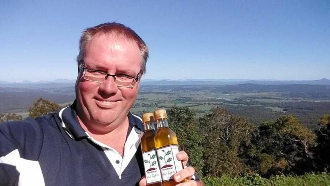 TUFFLES TRAVEL: Matt Hibberd with some truffle oil at a lookout en route to Mt Tambourine where he is officially opening another shop on Sunday. Picture: Contributed