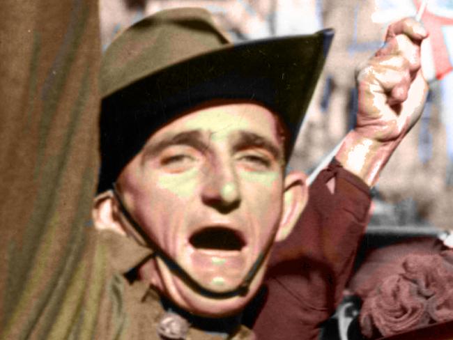 Colourised 15 Aug 1945. Although discharged in /1944 the man, ex- V301056 Pte Melbourne Bourke Saunders donned his uniform and travelled into the city to take part in the celebrations for VJ / VP Day - crowd lining Swanston Street waving flags and throwing streamers. WWII Pic/AWM Neg 181808 (NOT TO BE REPRODUCED WITHOUT PERMISSION). history Vic