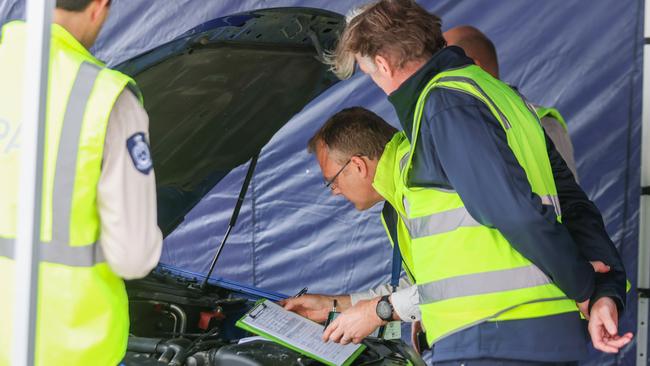 Officers run tests on a car’s engine. Picture: Brendan Beckett