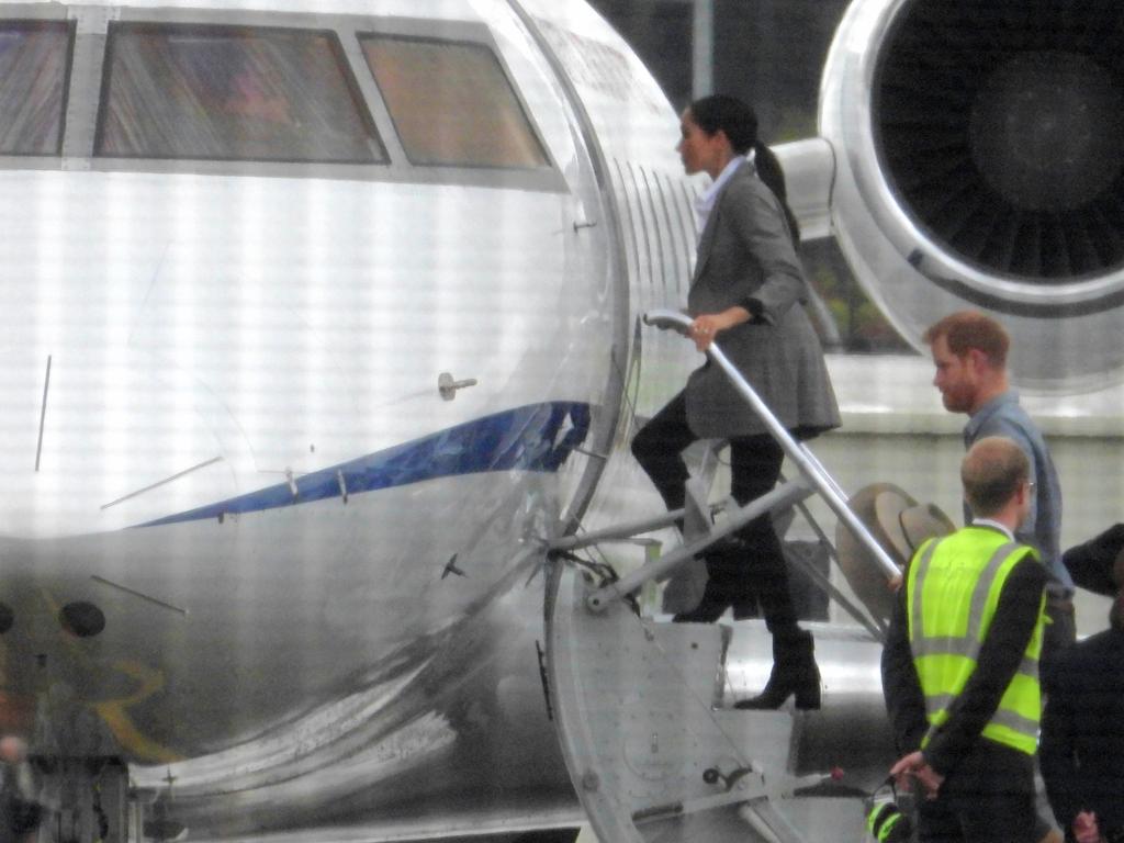 Harry and Meghan boarding a jet in Australia. Picture: John Grainger