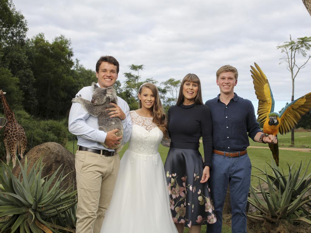 Chandler Powell, Bindi Irwin, Terri Irwin and Robert Irwin in a family photo. Chandler Powell is holding a koala and Robert Irwin is holding a macaw. Picture: Kate Berry