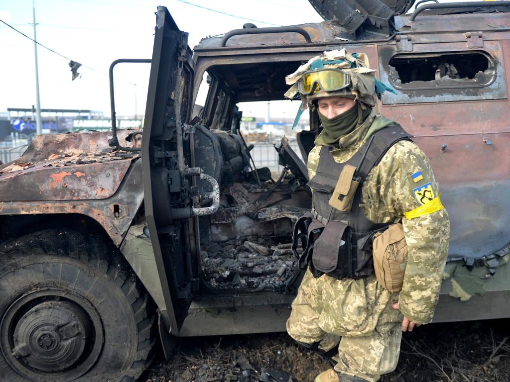 An Ukrainian fighter examines a destroyed Russian infantry mobility vehicle GAZ Tigr after the fight in Kharkiv on February 27, 2022. Picture: Sergey Bobok/AFP