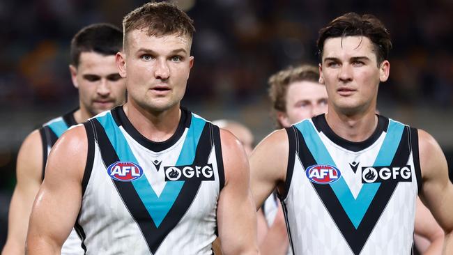 Ollie Wines (left) leaves the field after Saturday night’s loss to Brisbane. Picture: Michael Willson/AFL Photos via Getty Images