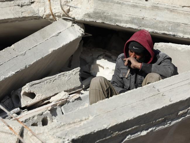 A Syrian man sits amid the rubble as he waits for new about family members stuck under the wreckage in the town of Harim in Syria's rebel-held northwestern Idlib province. Picture: AFP