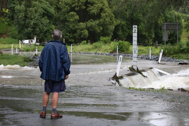 A local can’t find his way home across a raging Tallebudgera Creek. Picture: Glenn Hampson.