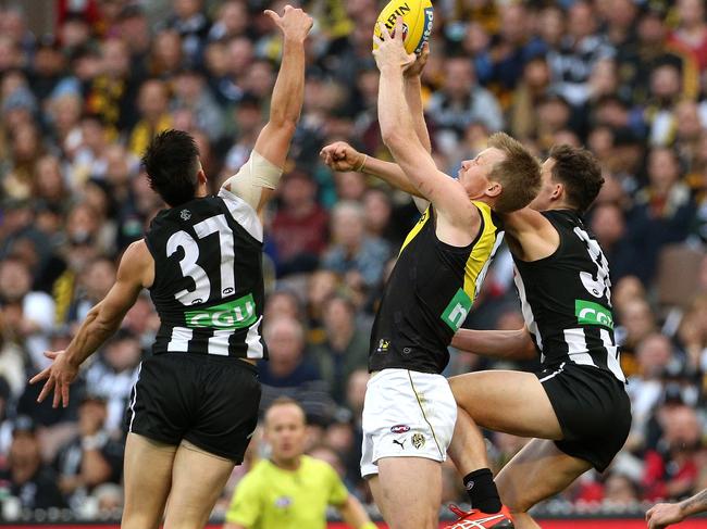 Jack Riewoldt of the Tigers (centre) marks between Brayden Maynard of the Magpies (left) and Flynn Appleby of the Magpies (right) during Round 6 AFL match between the Collingwood Magpies and the Richmond Tigers at the MCG in Melbourne, Sunday, April 29, 2018. (AAP Image/Hamish Blair) NO ARCHIVING, EDITORIAL USE ONLY