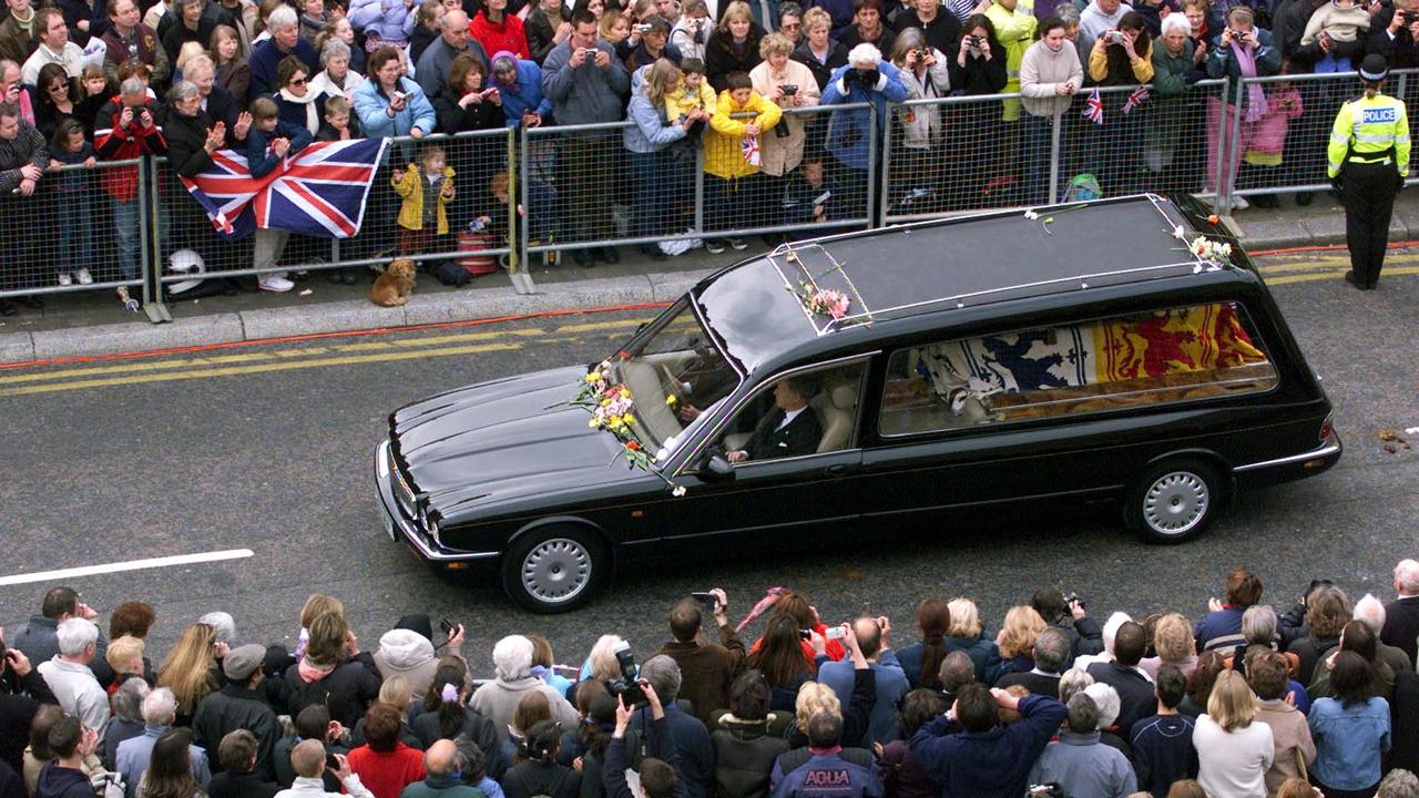 Crowds line the main street in Windsor in April 2002 as the hearse carrying the flag-draped coffin of the Queen Mother draws near to Windsor Castle, following her funeral service at Westminster Abbey. Picture: Chris Ison / PA/ WPA POOL / AFP