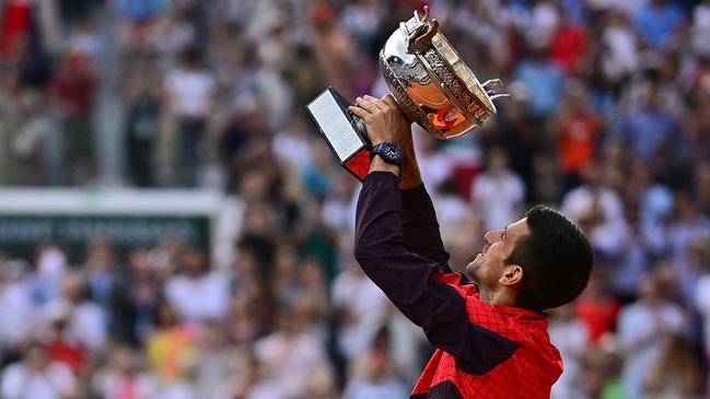 TOPSHOT - Serbia's Novak Djokovic raises his trophy as he celebrates his victory over Norway's Casper Ruud during their men's singles final match on day fifteen of the Roland-Garros Open tennis tournament at the Court Philippe-Chatrier in Paris on June 11, 2023. (Photo by JULIEN DE ROSA / AFP)