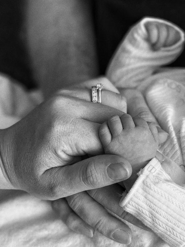 Kendall Gilding hold hands with her daughter Olive and husband Tim Morgan.