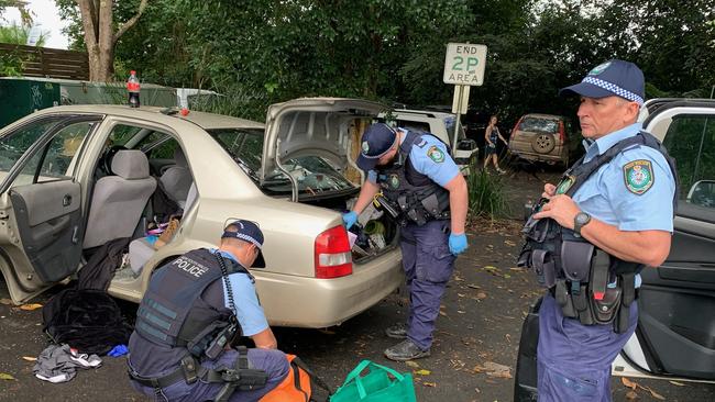 Police search a vehicle in Bellingen's town centre, believed to belong to a man in custody after he was allegedly seen threatening residents with a firearm in Macksville and Bowraville.