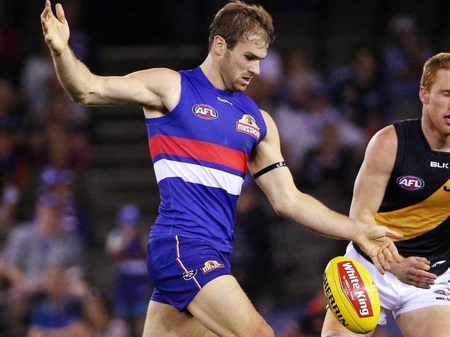 AFL -  Western Bulldogs v Richmond at Etihad Stadium. Stewart Crameri gets a kick away. April 5th 2014 . Picture : Colleen Petch.