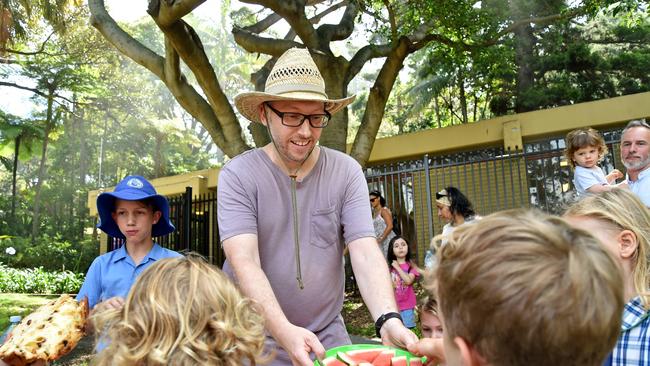 Ivanhoe Park Pre-School parent Rohan Gowland offers healthy fruit to supporters of the pre-school during a picnic at Manly on Monday December 17th. Picture: (AAP IMAGE / Troy Snook)