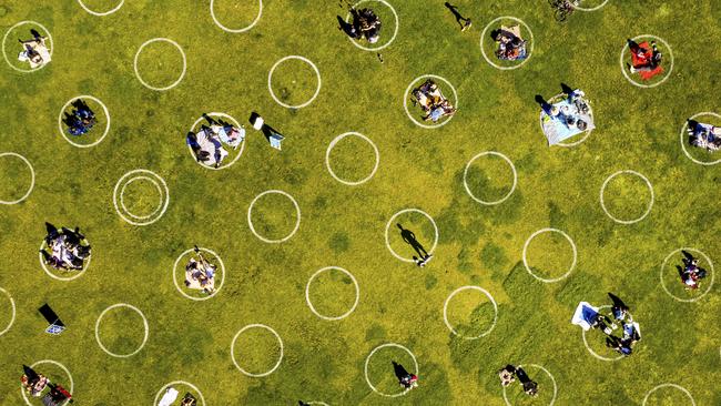 People in a San Francisco's park sit inside painted circles designed to help them keep a healthy distance to prevent the spread of the coronavirus. Picture: Noah Berger/AP