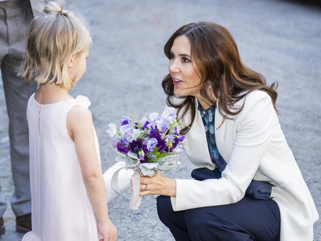 Queen Mary is given flowers by Petra Bruun Funch as she attends the Presentation of Grants from The Crown Princess Mary Scholarship at the University in Copenhagen, Denmark, on the same day as the ship ceremony. Picture: Getty Images