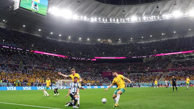 Alexis Mac Allister of Argentina battles for possession with Harry Souttar and Mathew Leckie