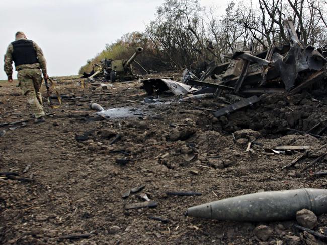 A Ukrainian serviceman walks past a column of destroyed military equipment near the village of Talakovka after an overnight bombing attack. AFP PHOTO / ANATOLII BOIKO