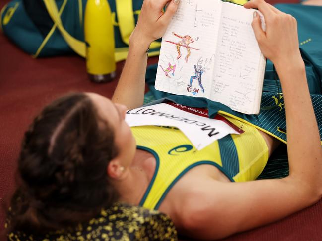 TOKYO, JAPAN - AUGUST 07: Nicola McDermott of Team Australia reads her journal as she competes in the Women's High Jump Final on day fifteen of the Tokyo 2020 Olympic Games at Olympic Stadium on August 07, 2021 in Tokyo, Japan. (Photo by David Ramos/Getty Images)