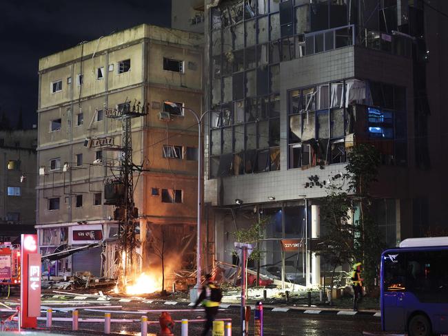 A member of the Israeli security forces walks at the scene after a major fire was extinguished in Ramat Gan, north of Tel Aviv, after a Hezbollah rocket attack. Picture: AFP