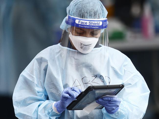 MELBOURNE, AUSTRALIA - NewsWire Photos AUGUST 20, 2021: A health worker is seen checking off bookings at the COVID testing centre next to the Palais Theatre at St Kilda. Picture: NCA NewsWire / Daniel Pockett