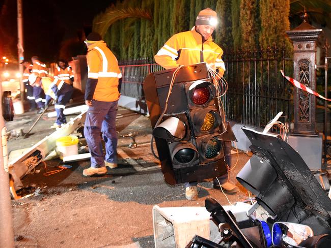 Workers clean up the scene where a tram derailed and crashed. Picture: Nicole Garmston