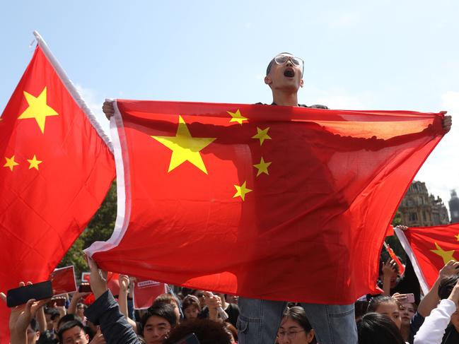 Counter-protesters hold up Chinese flags to oppose the protesters gathering in central London to attend a march organised by StandwithHK and D4HK  in support of Pro-democracy protests in Hong Kong, on August 17, 2019. - Hong Kong's pro-democracy movement faces a major test this weekend as it tries to muster another huge crowd following criticism over a recent violent airport protest and as concerns mount over Beijing's next move. (Photo by Isabel Infantes / AFP)