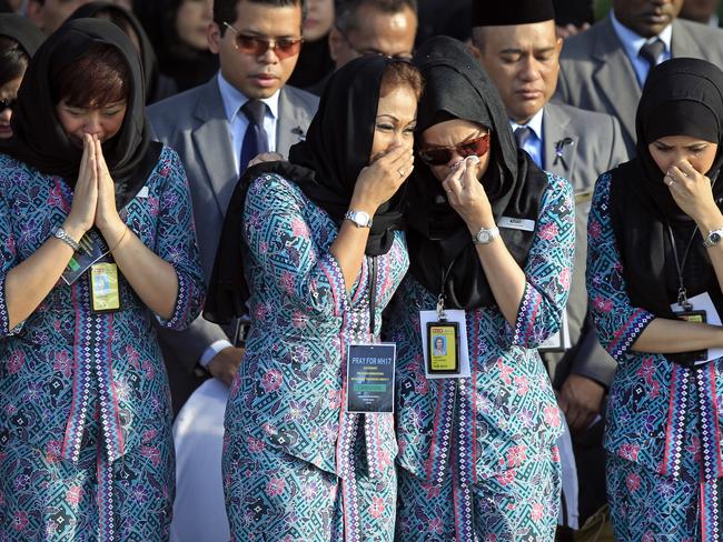 Malaysia Airlines crew members cry during a handover ceremony of bodies of the downed Flight MH17. Picture: Lai Seng Sin