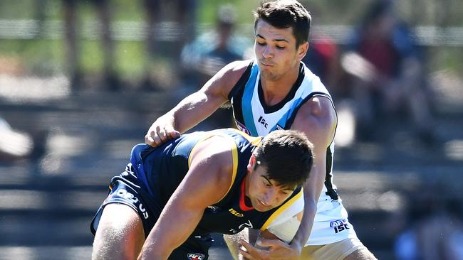 Patrick Wilson of the Crows under pressure from Ryan Burton of the Power during the Under 23 trial game at Thebarton Oval on Saturday. Picture: AAP/Mark Brake