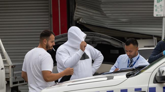 Police speak to men out the front of the store. Picture: Jason Edwards