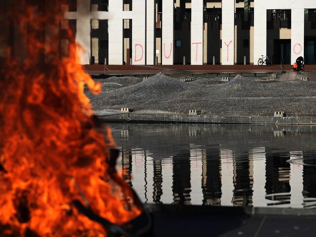 A fire burns on the forecourt as Extinction Rebellion protesters sprayed the front of Parliament House. Picture: NCA NewsWire / Gary Ramage