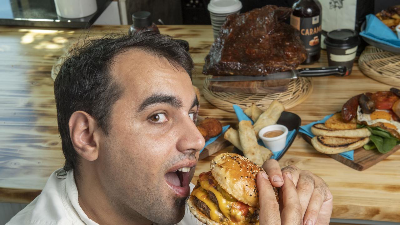 Executive chef Mark Aboud tries out a burger at his new cafe. Picture: Nev Madsen.