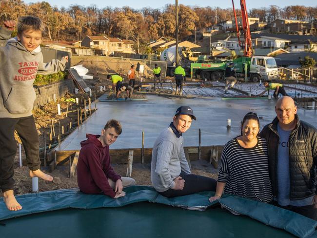 The Creary family stand on their block of land on Flora Place in Tathra as concrete is poured in the process of rebuilding their home. From left: Chad, 7, Brock, 14, Duke, 15, Alexis and Mitch. Picture: Sean Davey