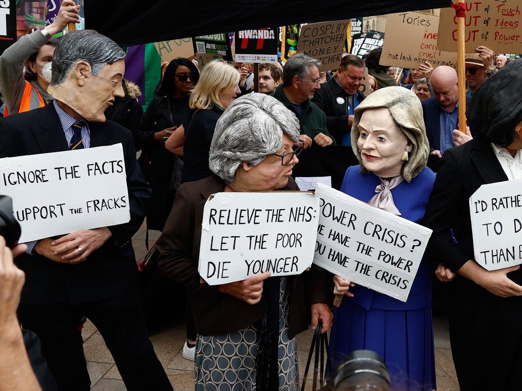 Protesters dressed as UK leaders stand with placards as they take part in a protest at Victoria Square on the first day of the Conservative Party Conference.
