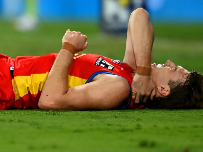 Gold Coast’s Charlie Ballard grabs his neck after being struck by Melbourne’s Jacob van Rooyen. Picture: Albert Perez/AFL Photos via Getty Images