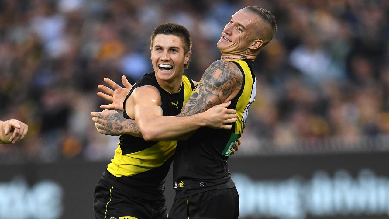 Liam Baker (centre) and Dustin Martin (right) of the Tigers react after Baker kicked a goal during the Round 9 AFL match between the Richmond Tigers and the Hawthorn Hawks at the MCG in Melbourne, Sunday, May 19, 2019. (AAP Image/Julian Smith) NO ARCHIVING, EDITORIAL USE ONLY